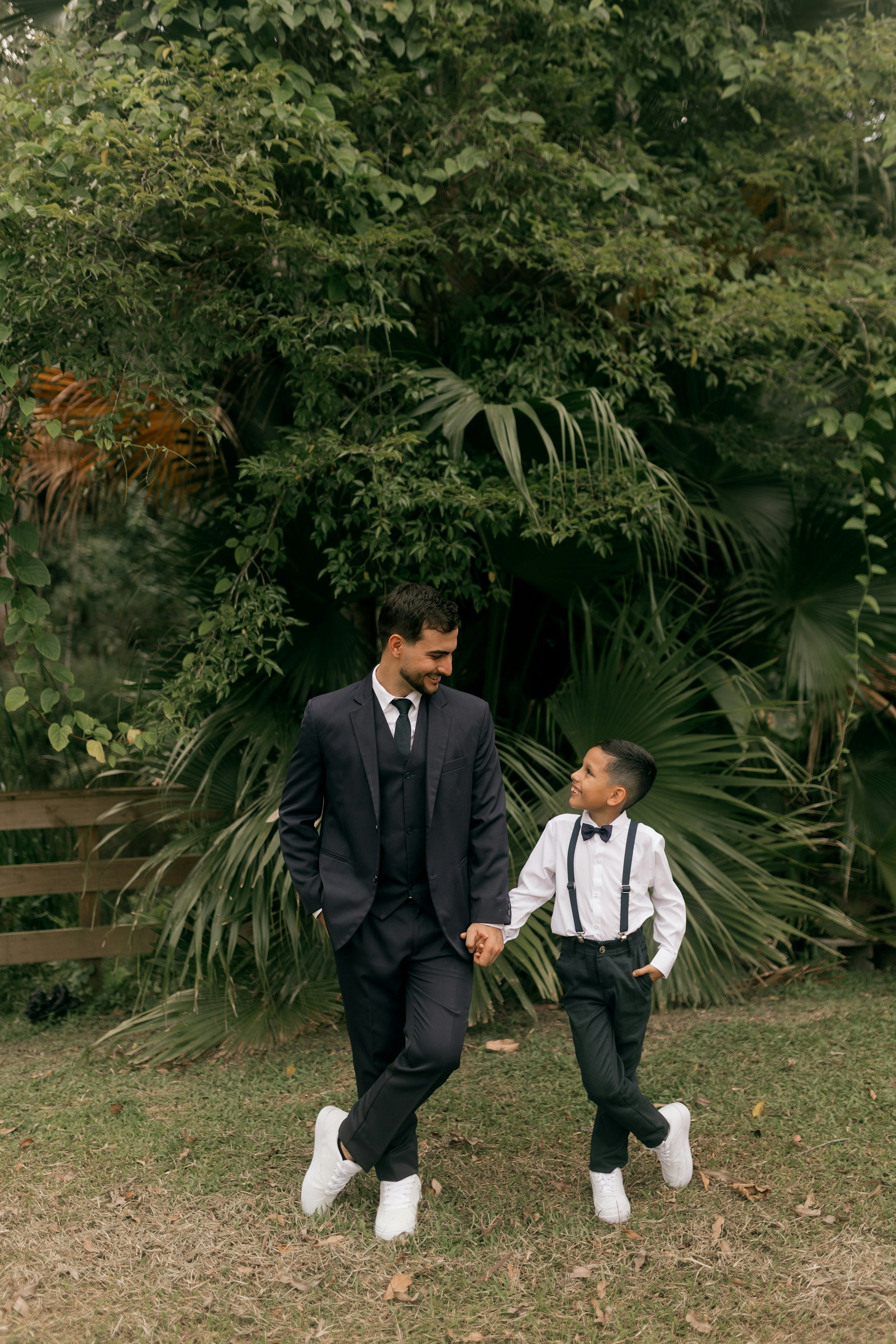 Father and son in matching suits holding hands