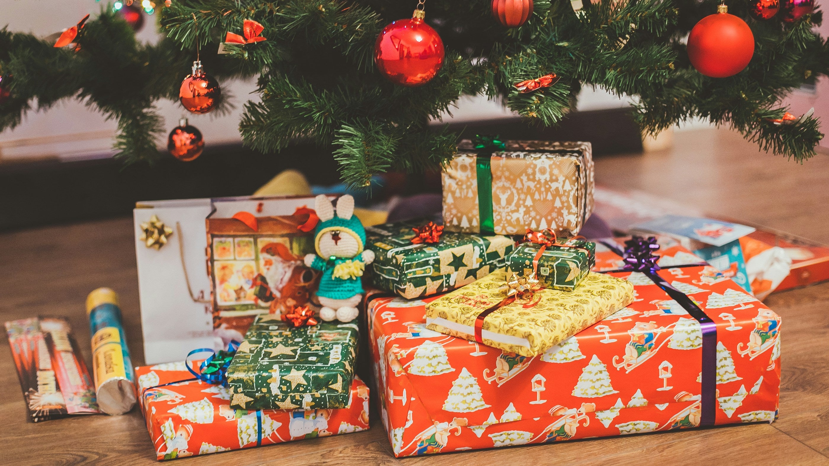 Colorful wrapped Christmas gifts under a decorated Christmas tree