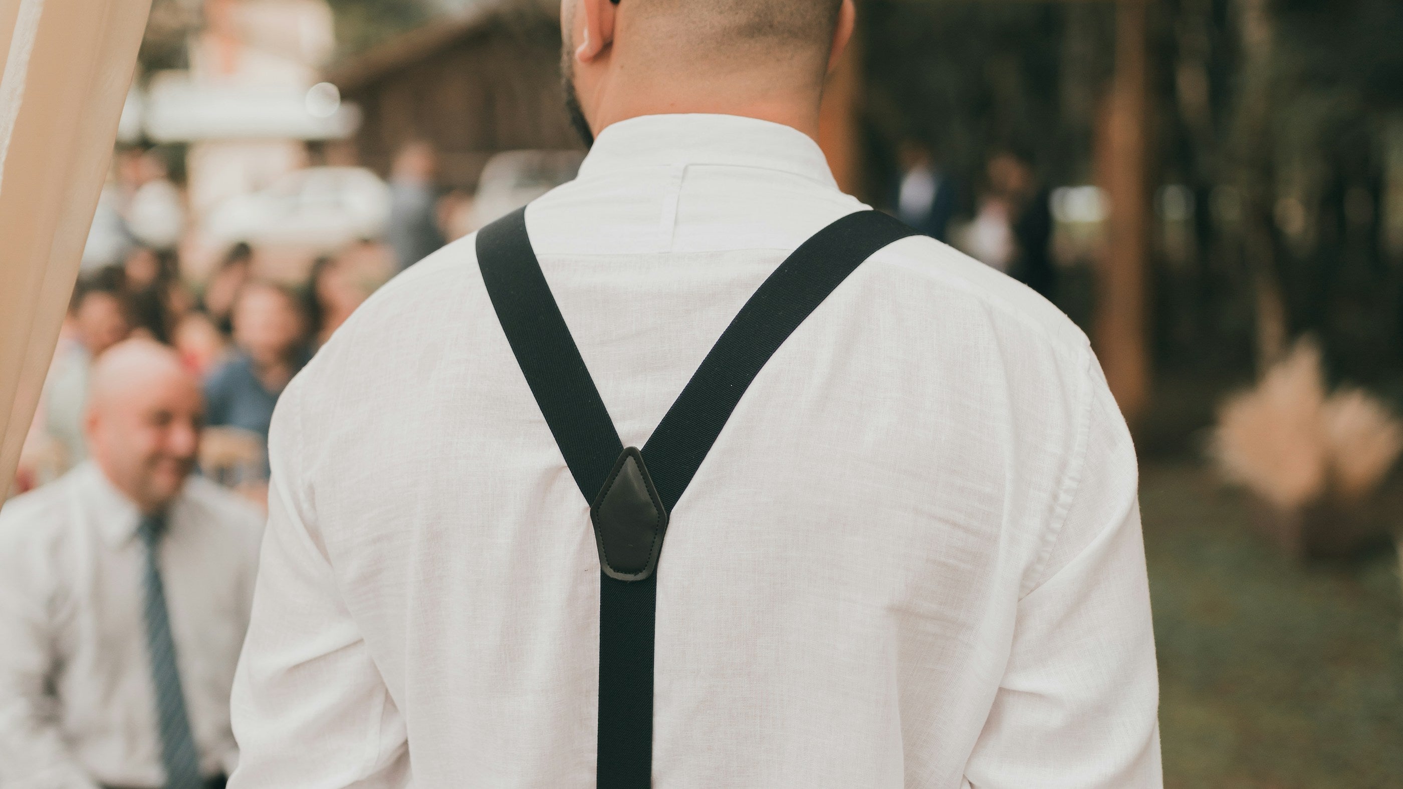 Man wearing a white shirt and black suspenders
