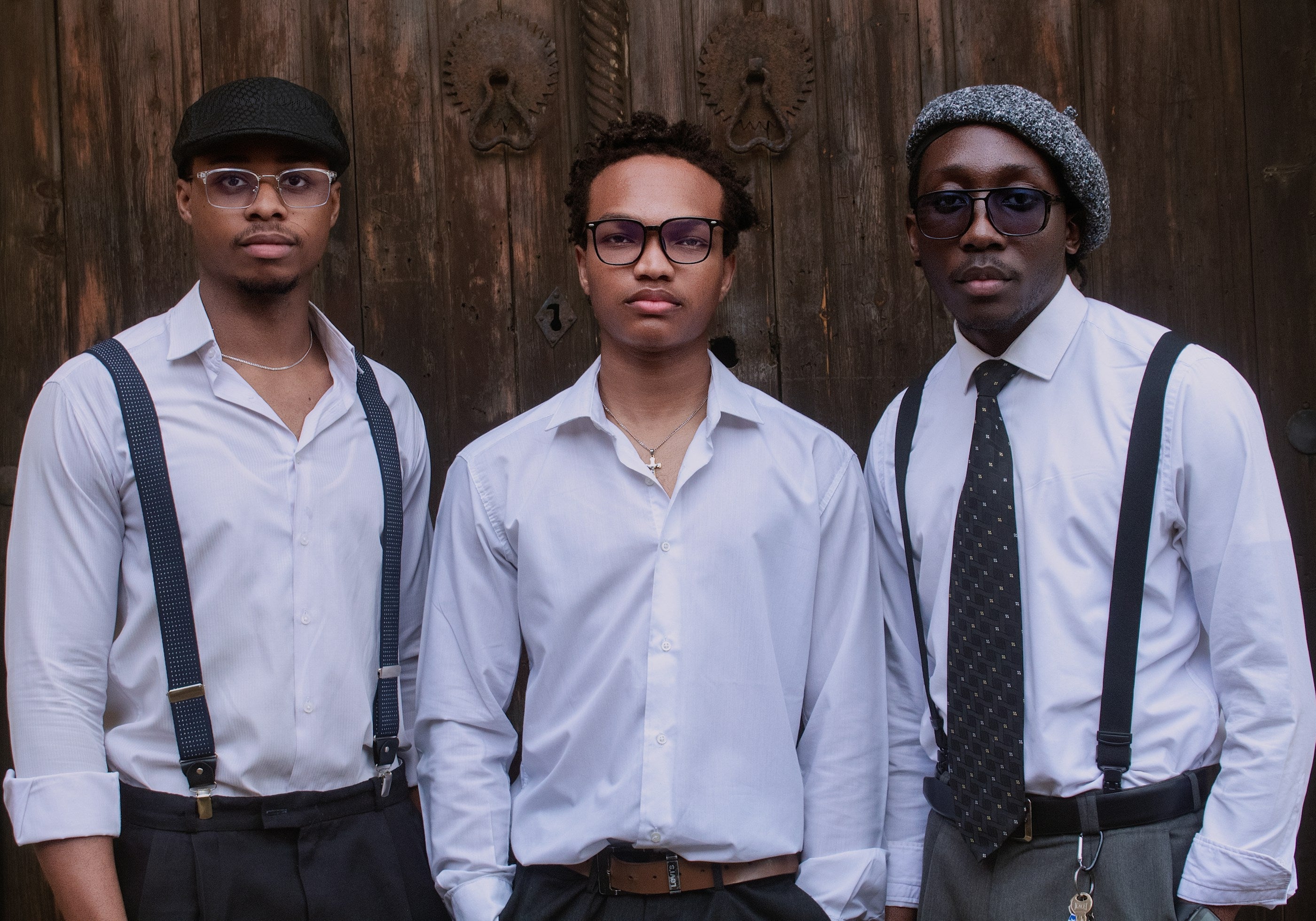 Three men in white shirts and suspenders