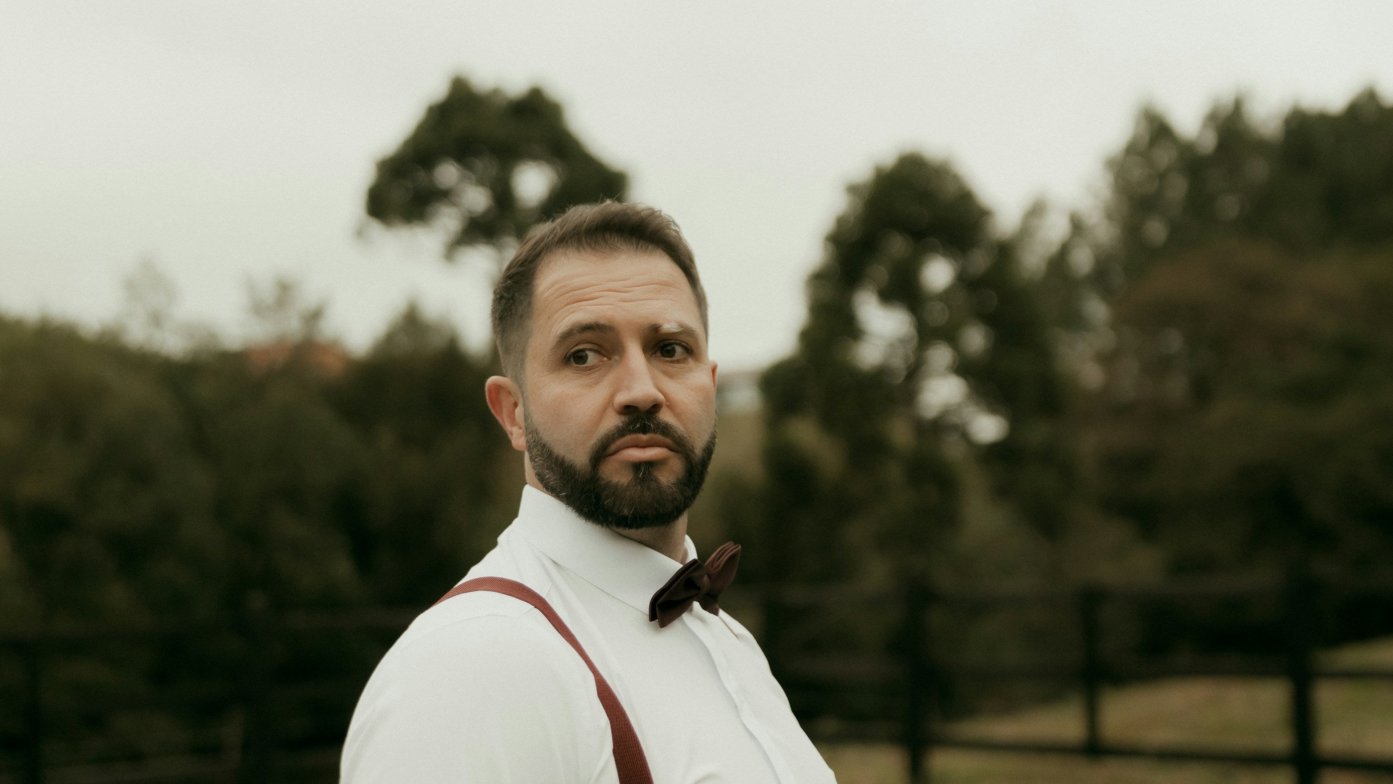 Man wearing a bow tie and suspenders for a wedding