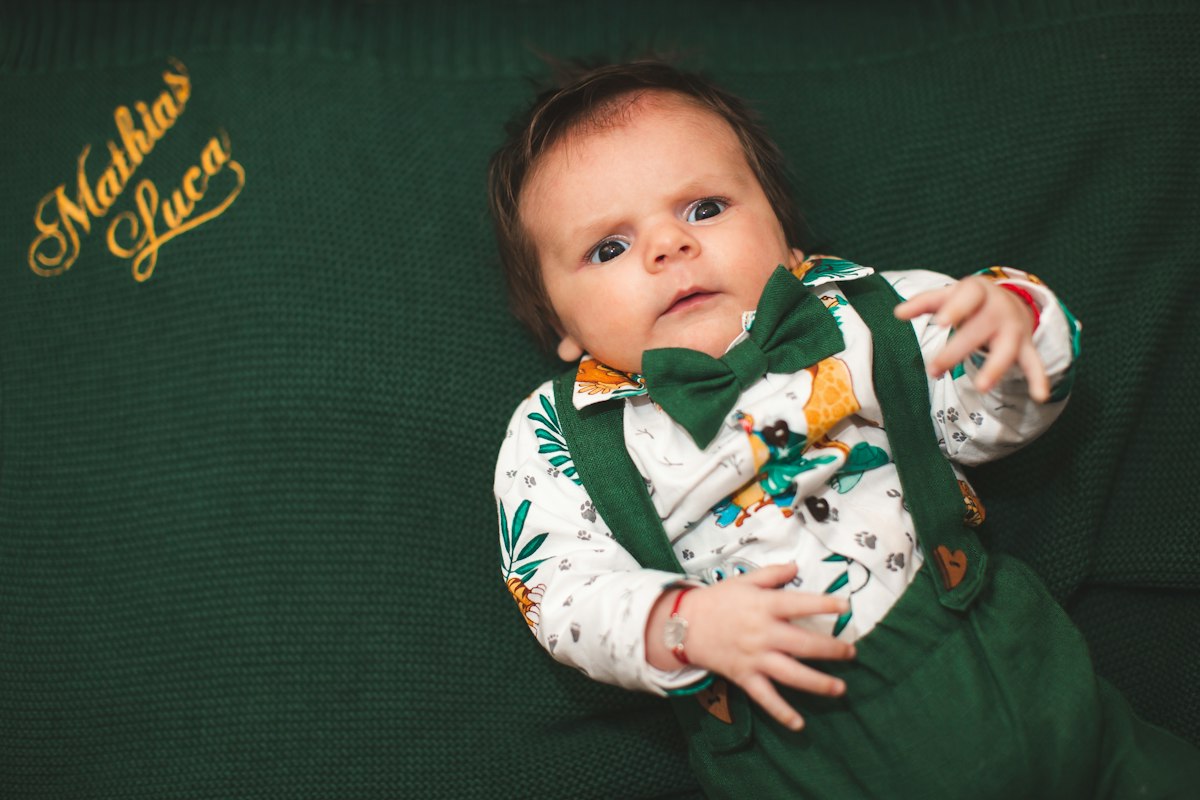 Baby in a green outfit with a bow tie