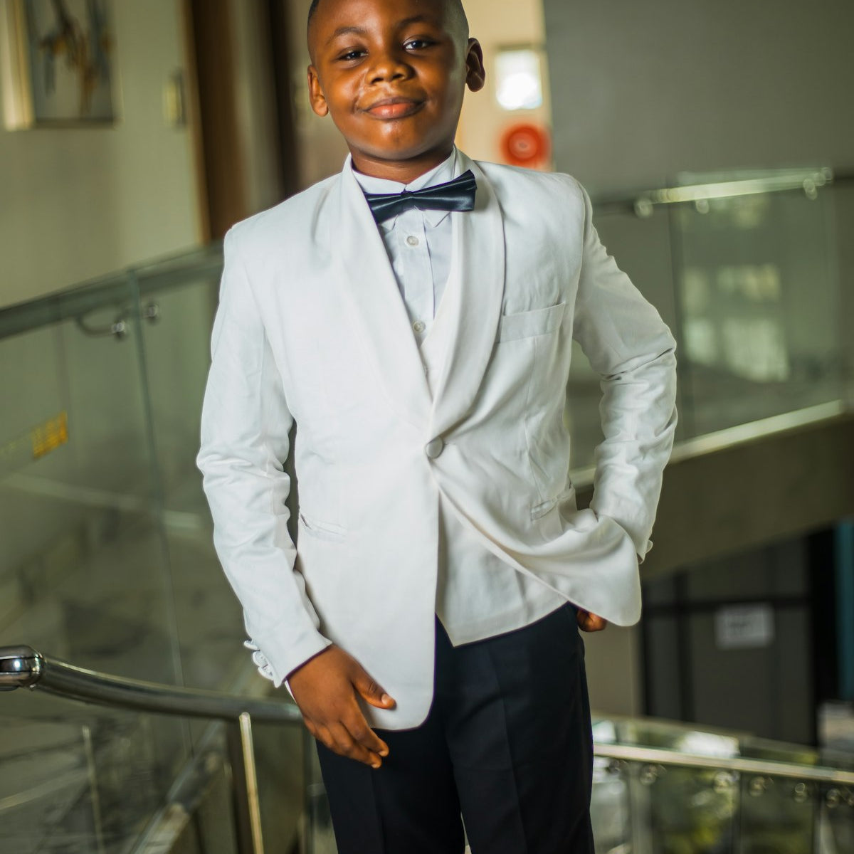 Young boy in a white suit and bow tie