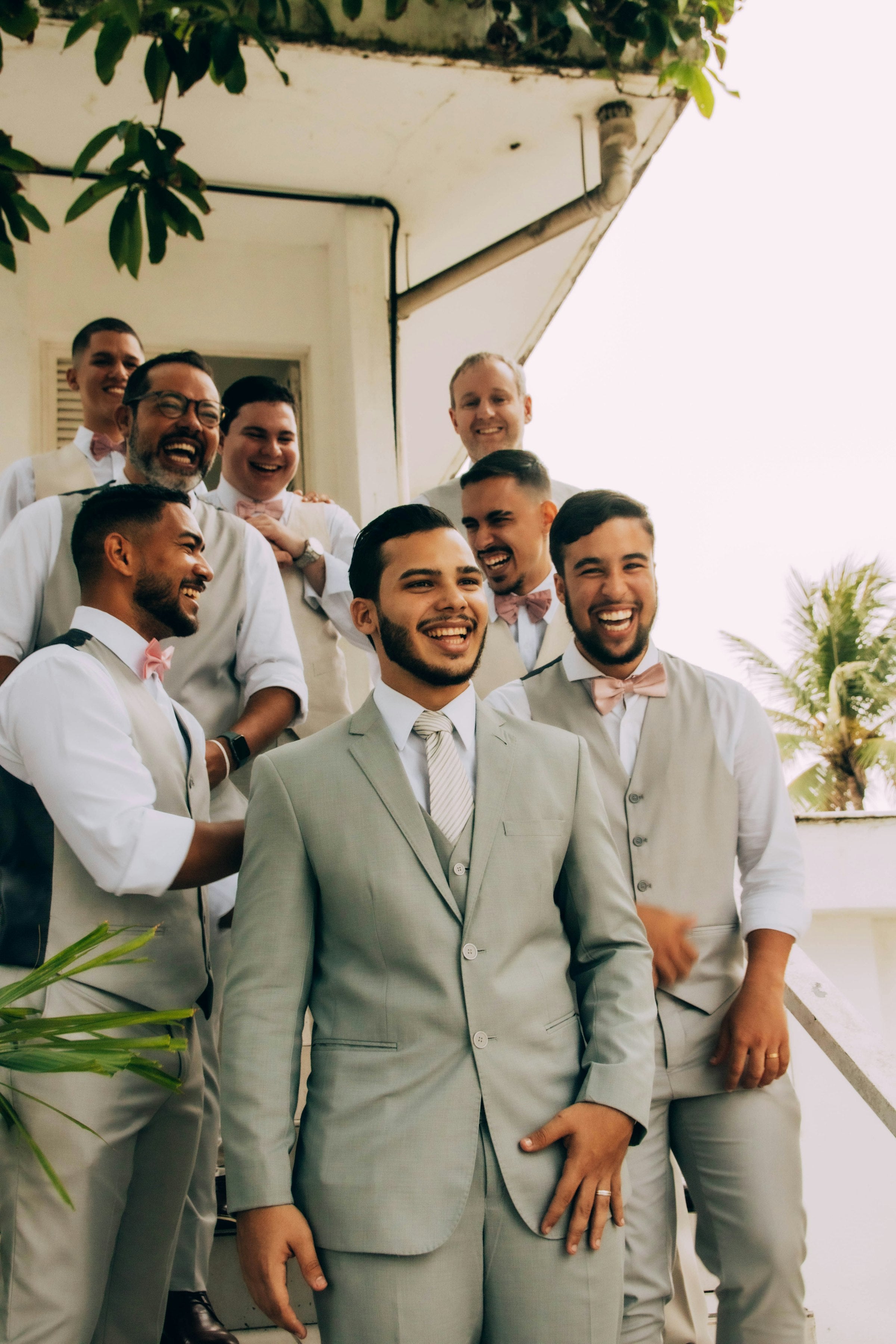 Groom and groomsmen smiling together at a wedding
