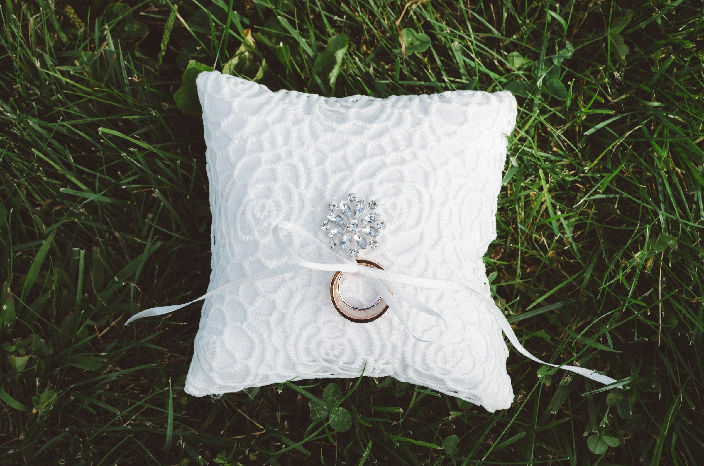 Wedding ring pillow resting on the grass
